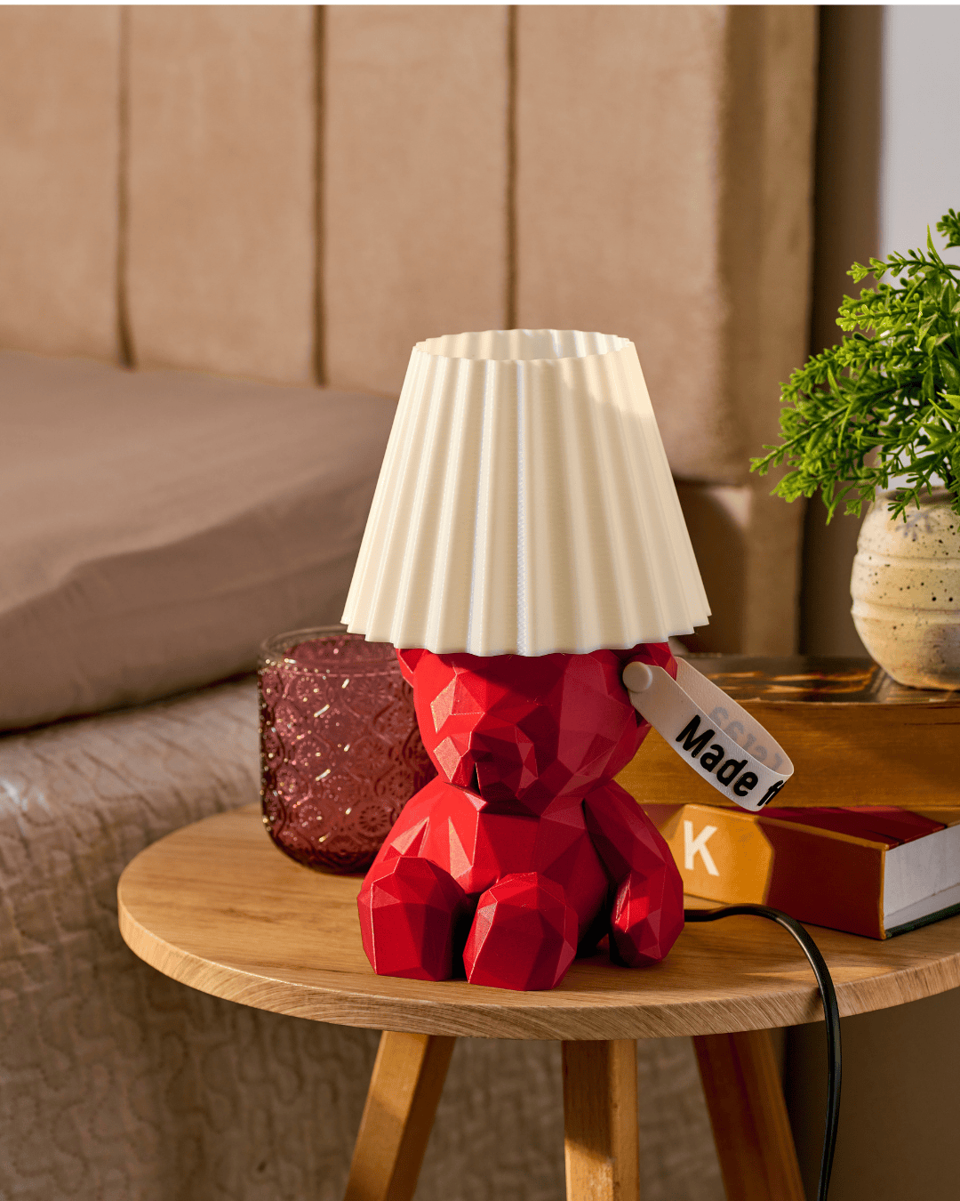 Red 3D printed teddy bear lamp with a personalized name tag on the ear in a wooden table