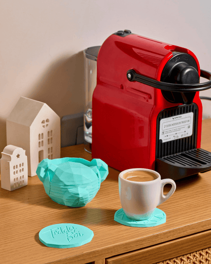 3D printed modern geometric Teddy Boi coasters with a faceted docking holder on a coffee table