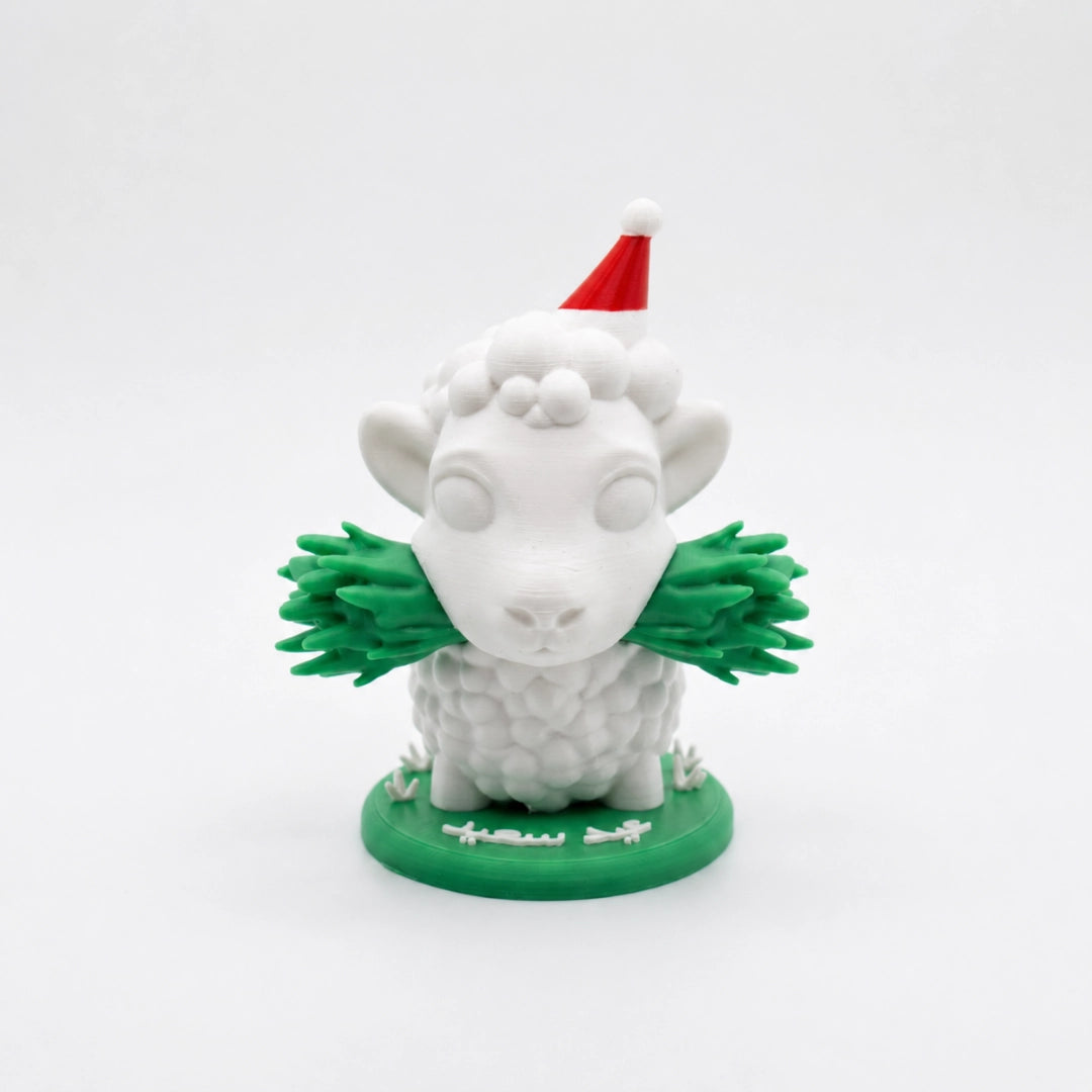White figurine of a sheep with a red hat and green scarf on a white background