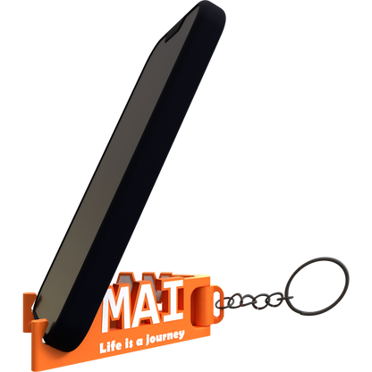 A black mobile phone stand with an orange keychain that has the text 'MAI Life is a journey' on it.